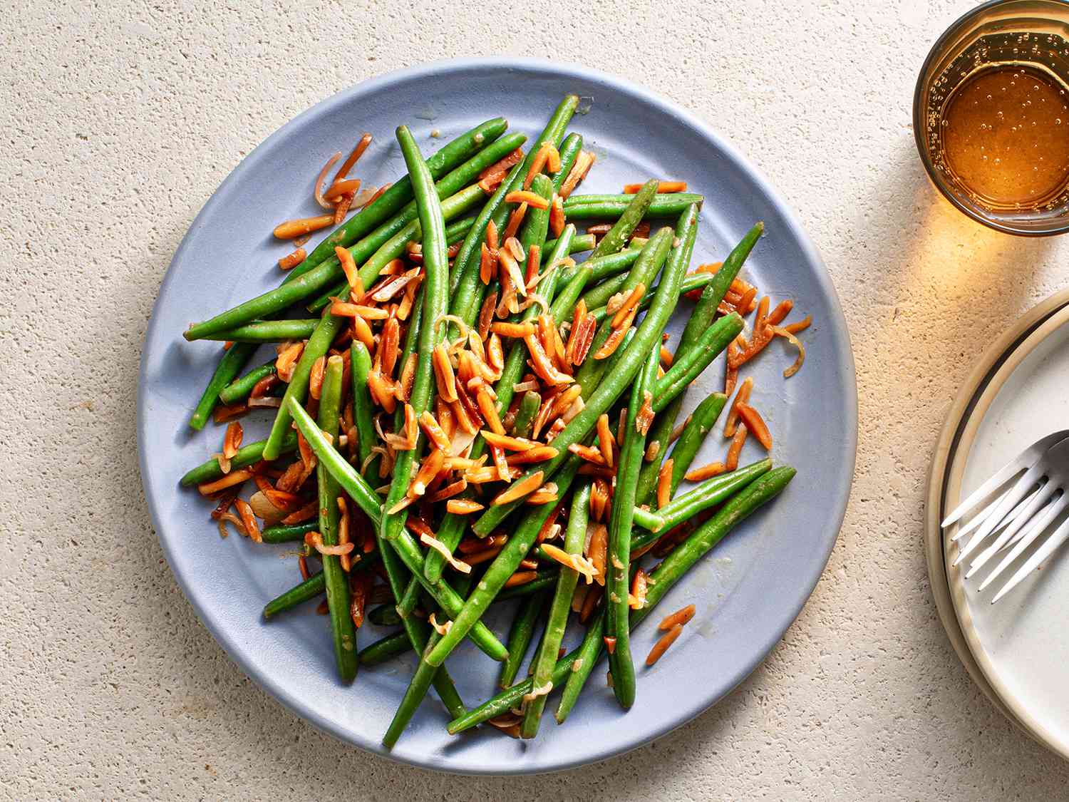 The composed green beans on a blue ceramic plate.