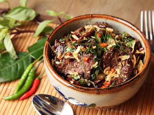 A ceramic bowl filled with Thai-style beef with basil and chiles.