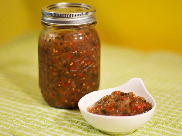 The finished relish, packed into a jar with a few spoonfuls removed to a white ramekin.