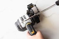 An overhead view of a person using an electric knife sharpener