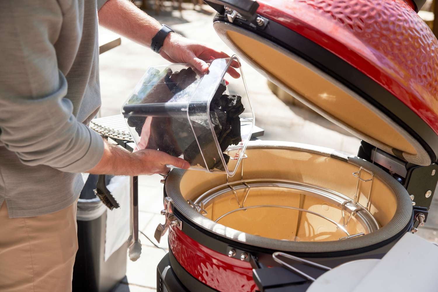 a person adding lump charcoal to the Konnected Joe