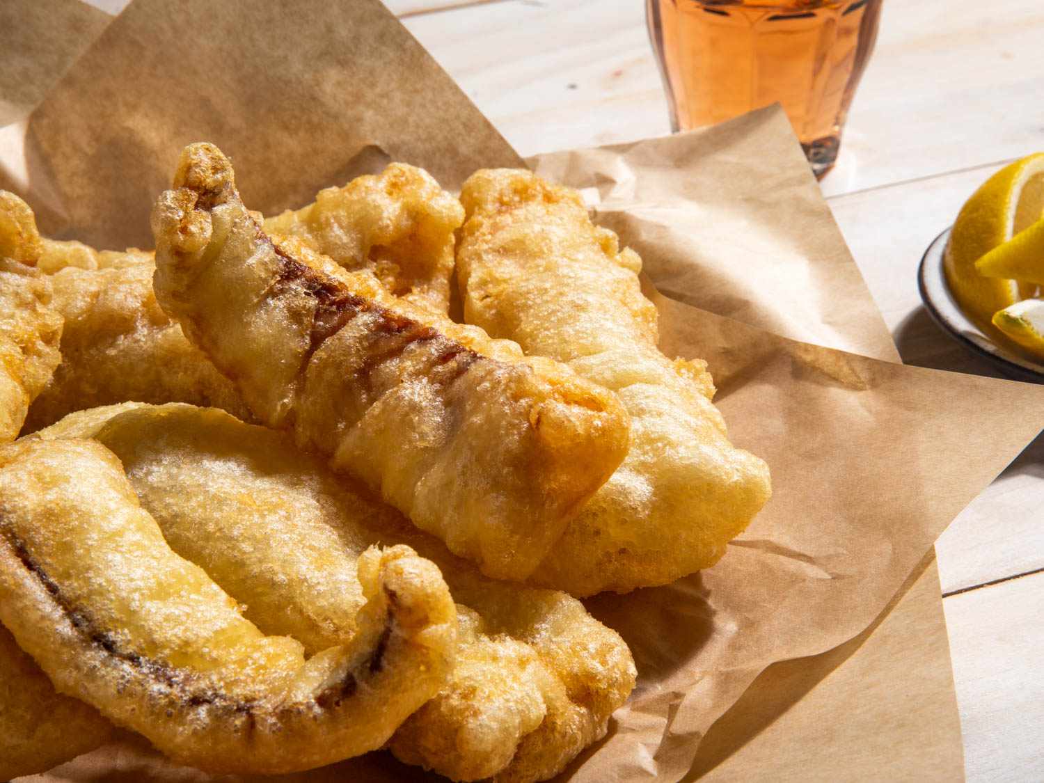 A closeup of a serving platter of fried salt cod fillets.