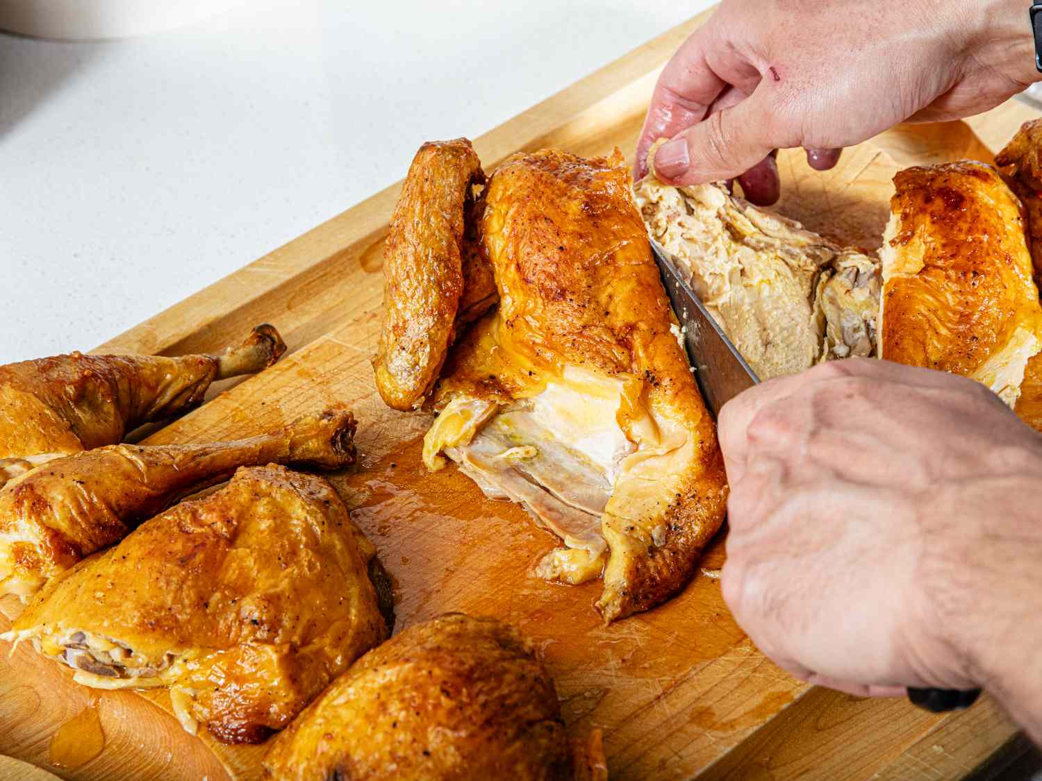 Overhead view of the carving of a roasted spatchcocked chicken