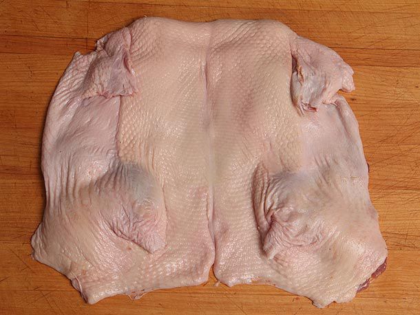 Whole boned-out duck flattened against cutting board with skin side up 
