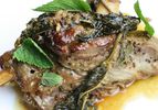 Closeup of braised lamb shank with mustard and fresh mint leaves