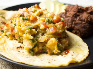 A plate of Tex-Mex migas next to beans.