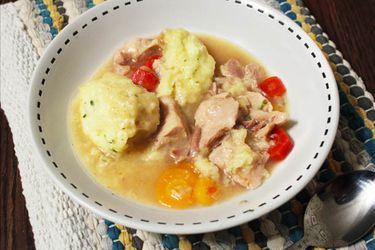 Overhead view of gluten-free chicken and dumplings, served in a shallow white bowl.