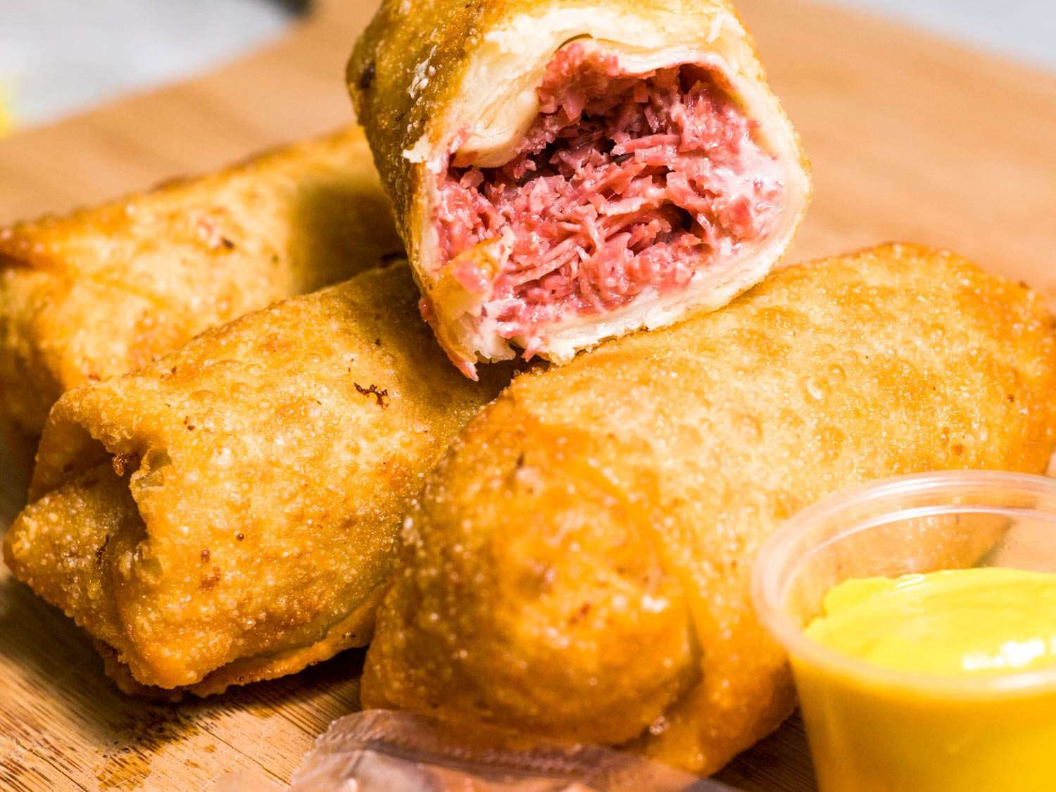 Three Detroit corned beef egg rolls with a split open one on top.