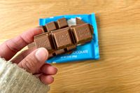 A person holding pieces of Ritter Sport Alpine Milk Chocolate