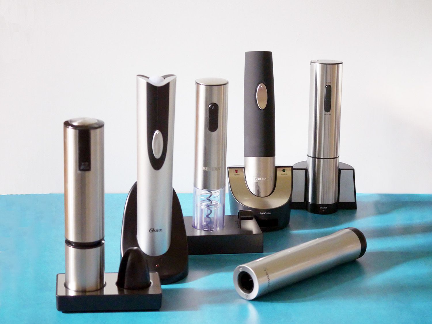 Six electric corkscrews on a blue countertop 