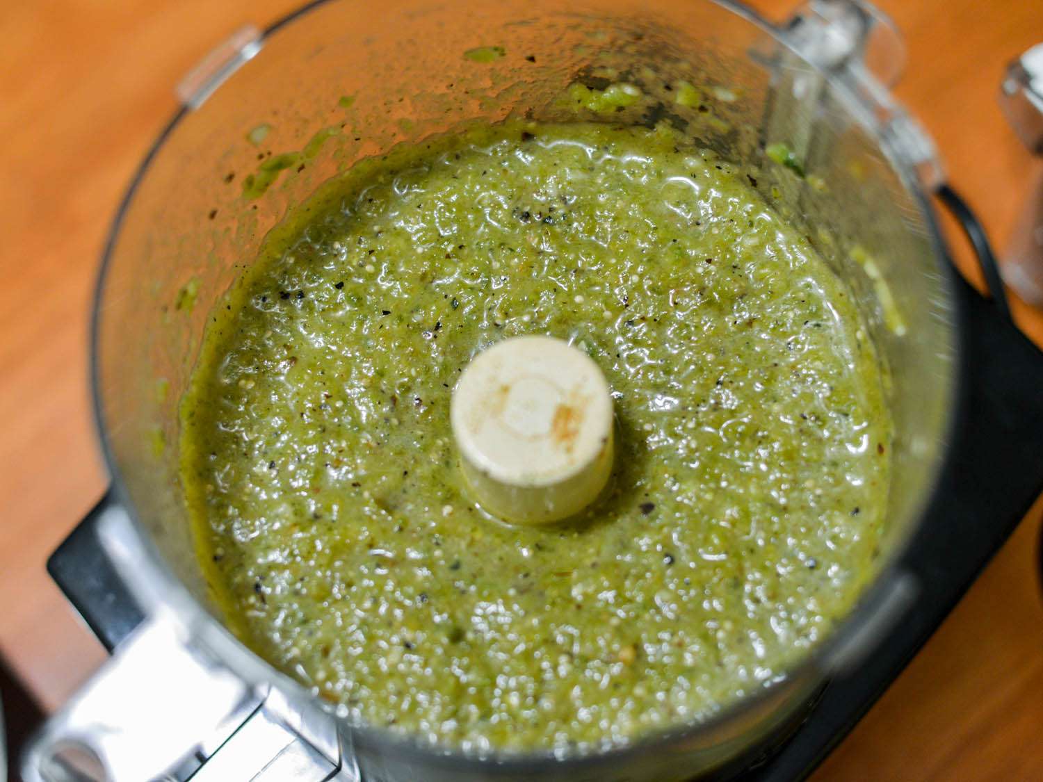 Puréed roasted peppers and tomatillos mixture inside food processor