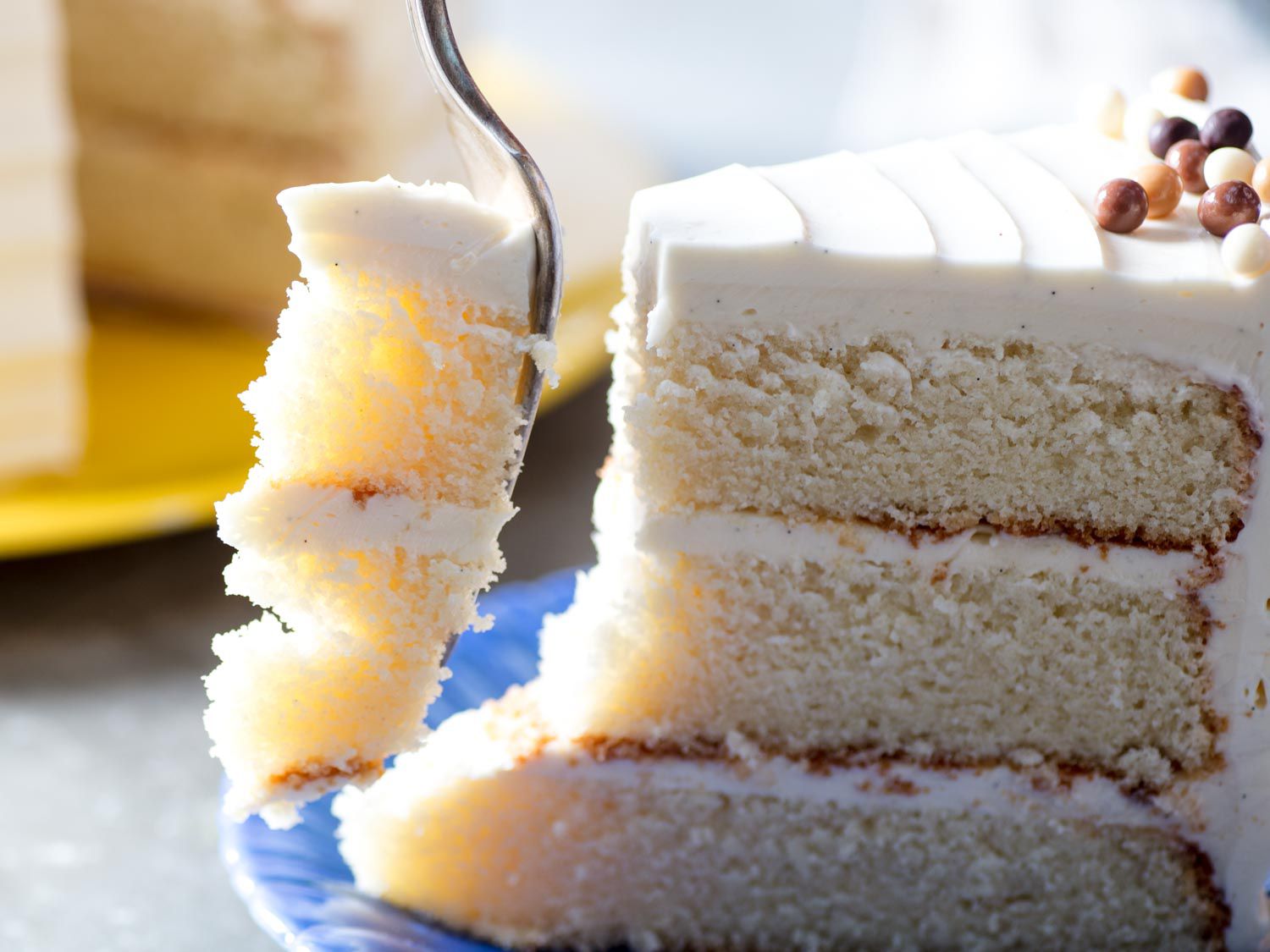 A fork cutting through a slice of layered butter cake. 