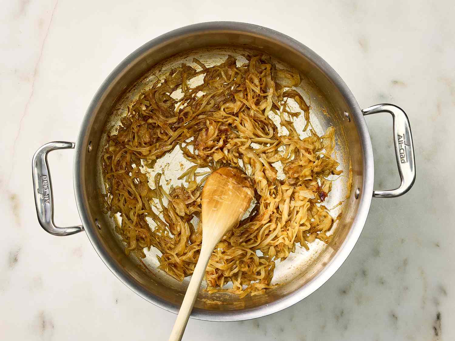 softened and browned in a pot, with a wooden spoon in a marble surface
