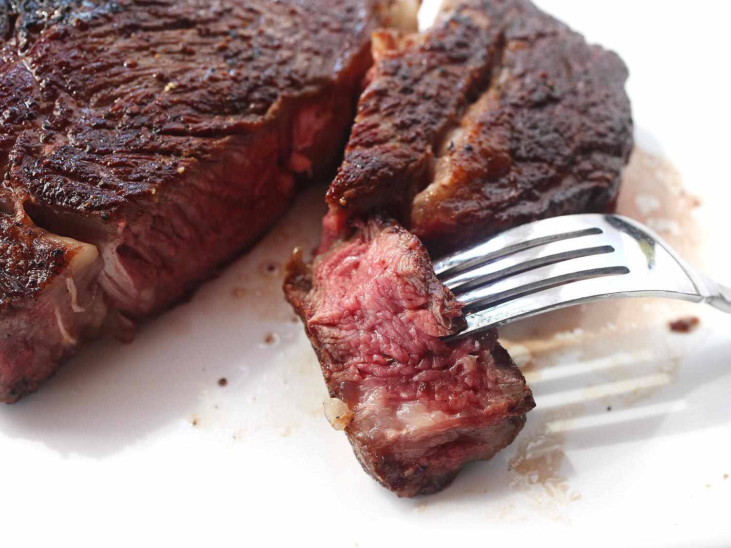 Slice of steak on a fork from a reverse-seared ribeye