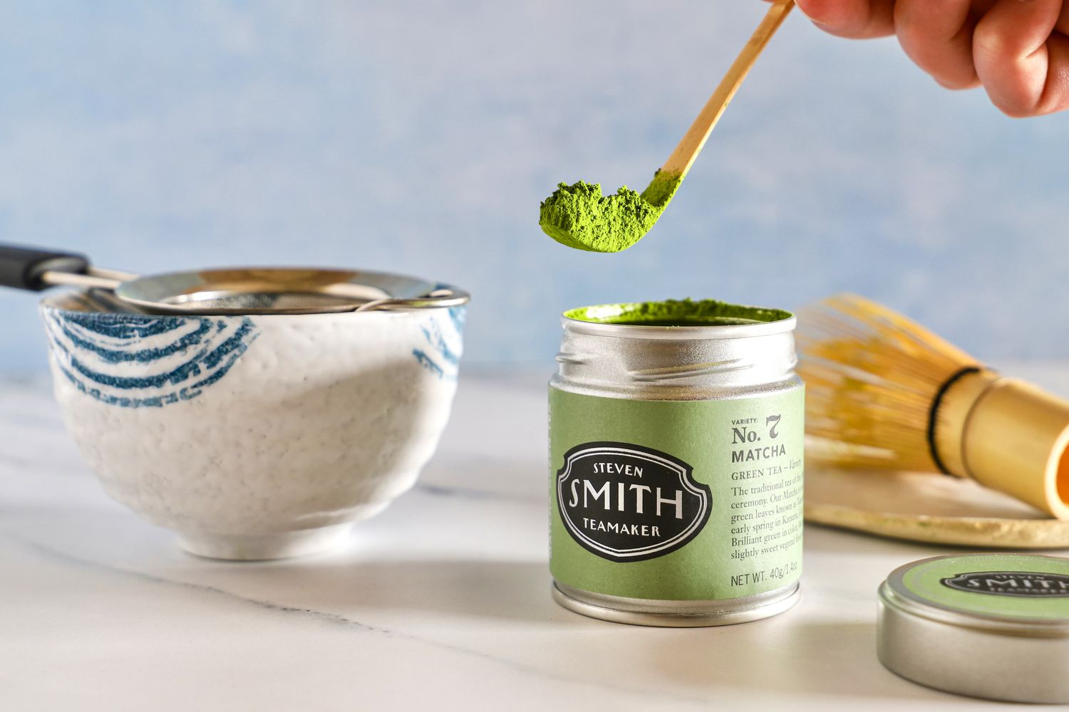 Matcha being scooped from a tin.