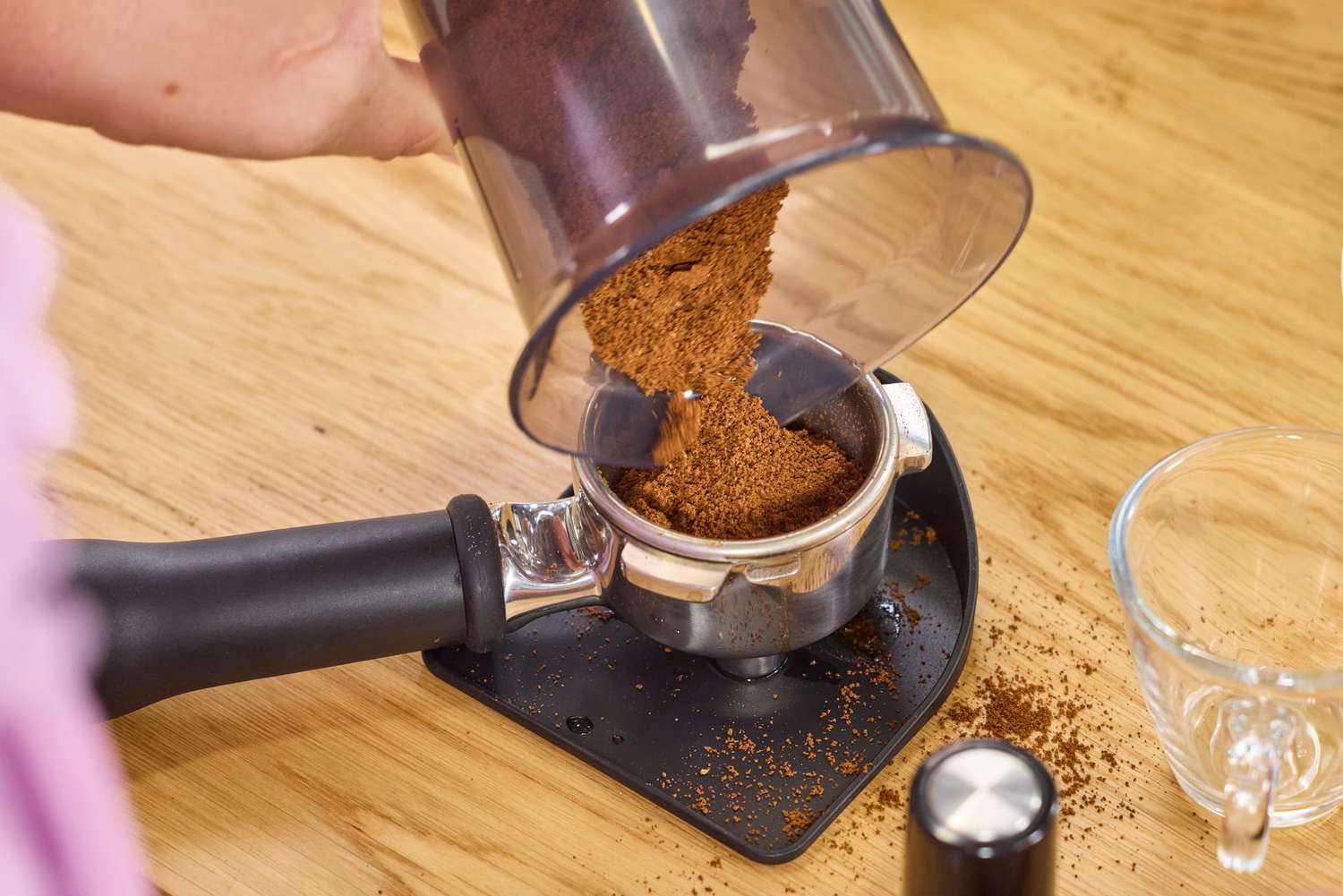 Ground coffee made in the Baratza Sette 270 Conical Burr Grinder is poured into an espresso portafilter