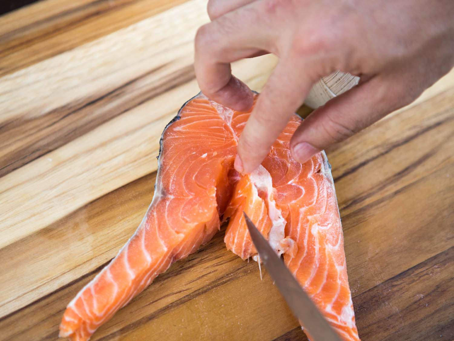 Probing to feel for additional pinbones in a salmon steak.