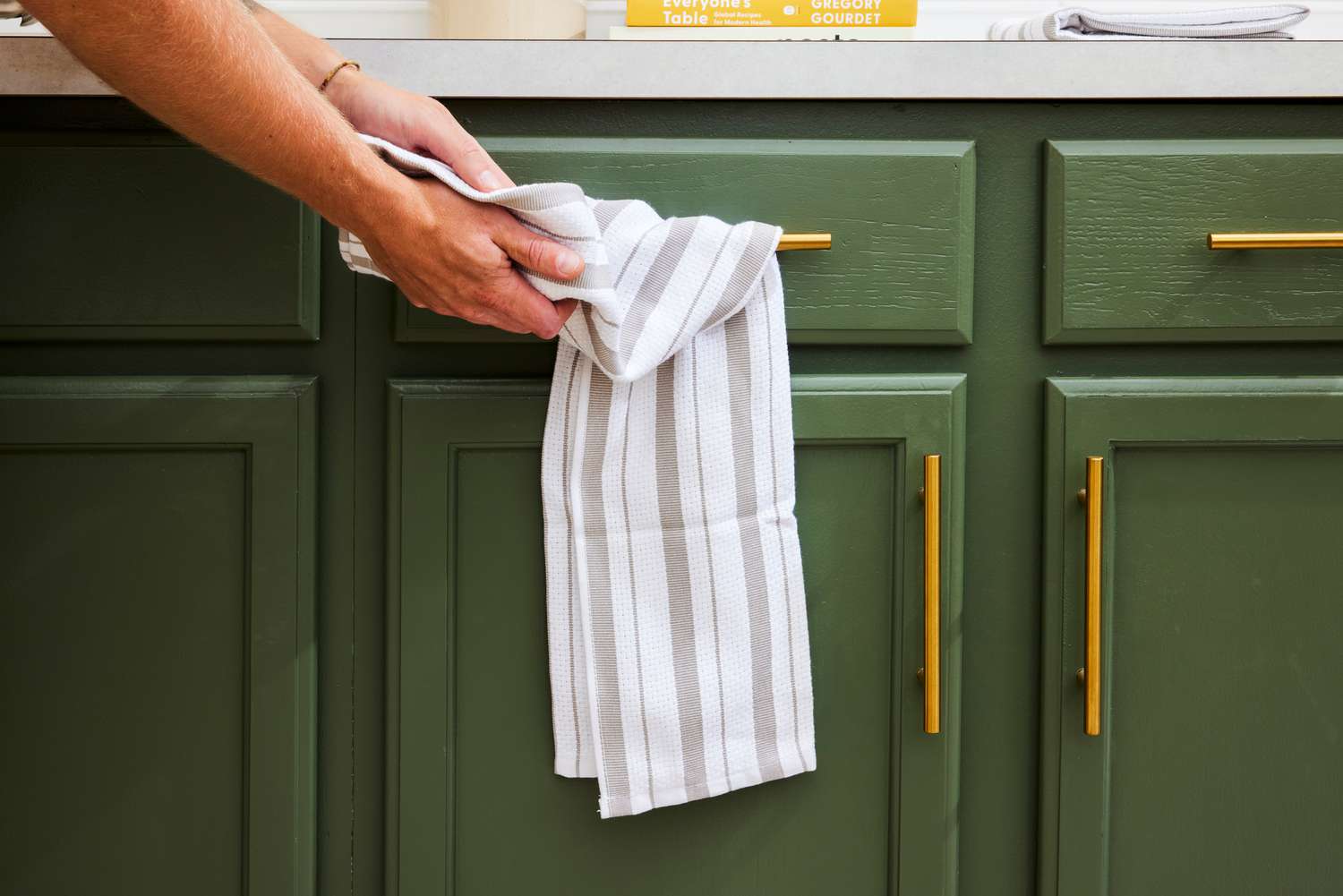 A person drying their hands on a striped dish towel.