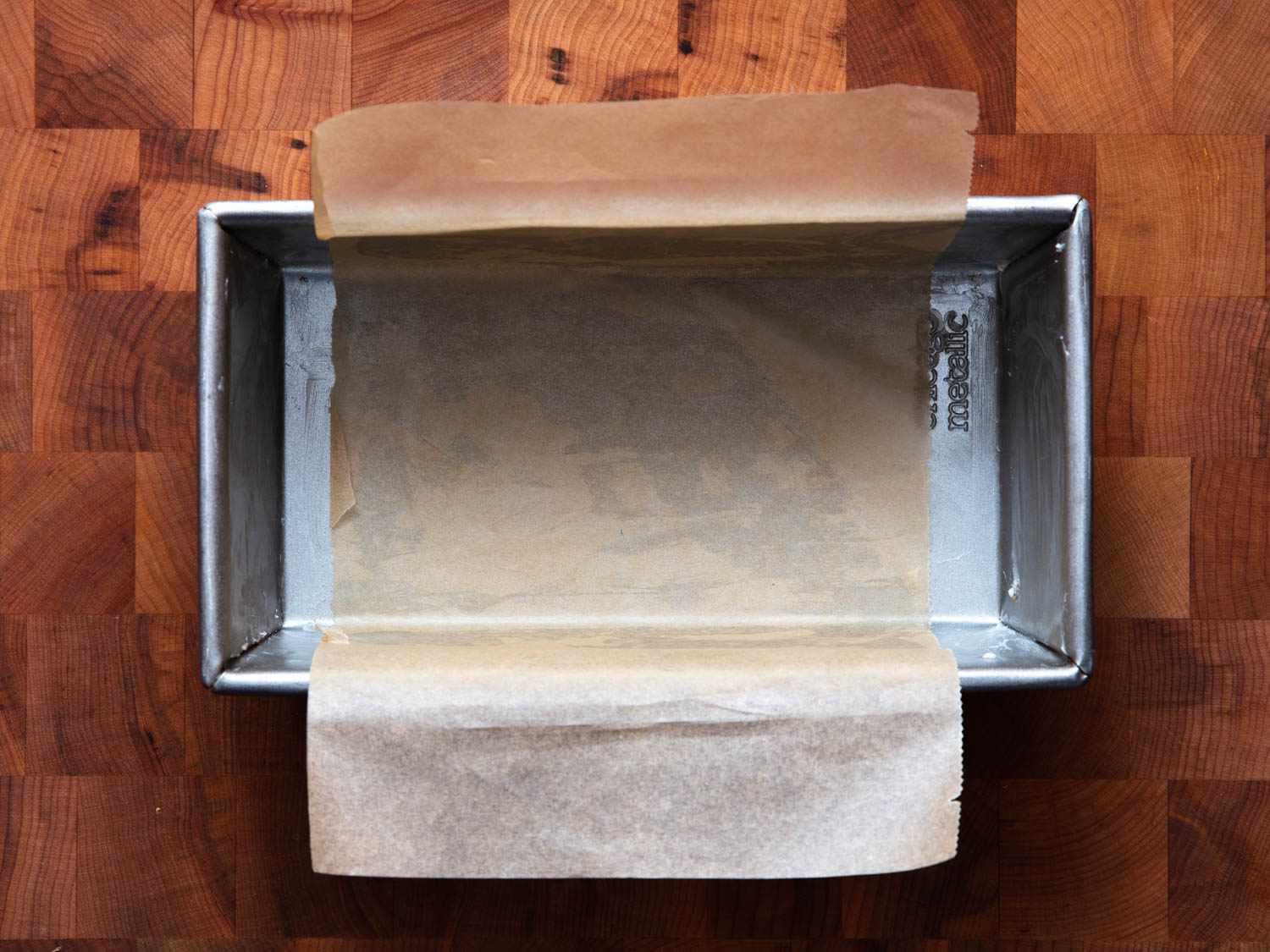 A prepared greased loaf pan with a parchment paper "sling".
