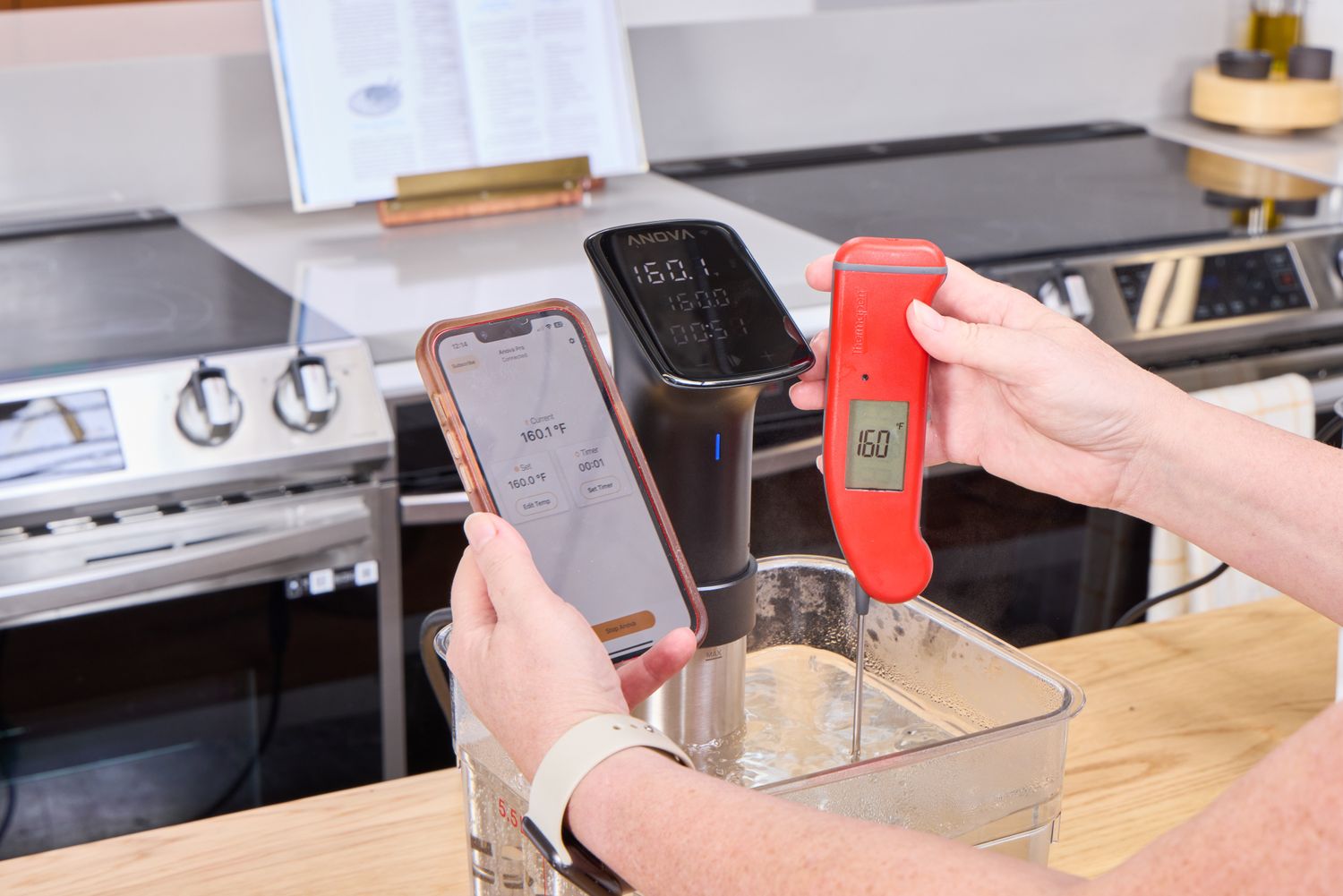 A person takes the temperature of water boiled using the Anova Culinary Precision Cooker Pro
