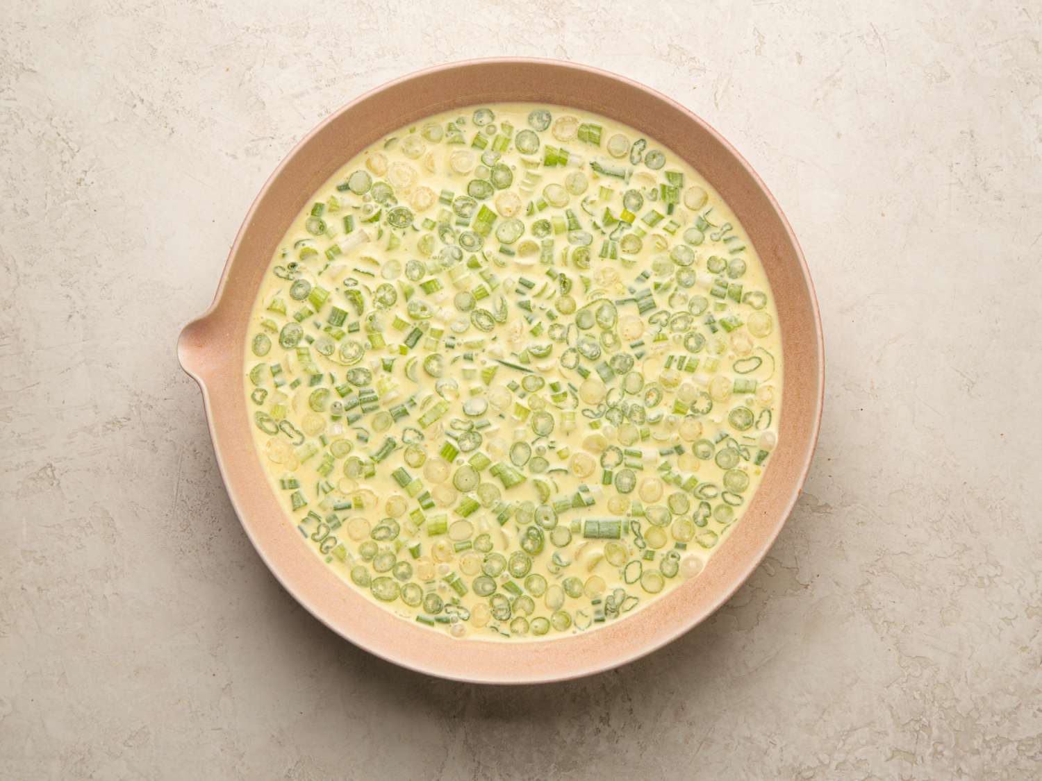 Overhead view of batter mixture in a pink bowl