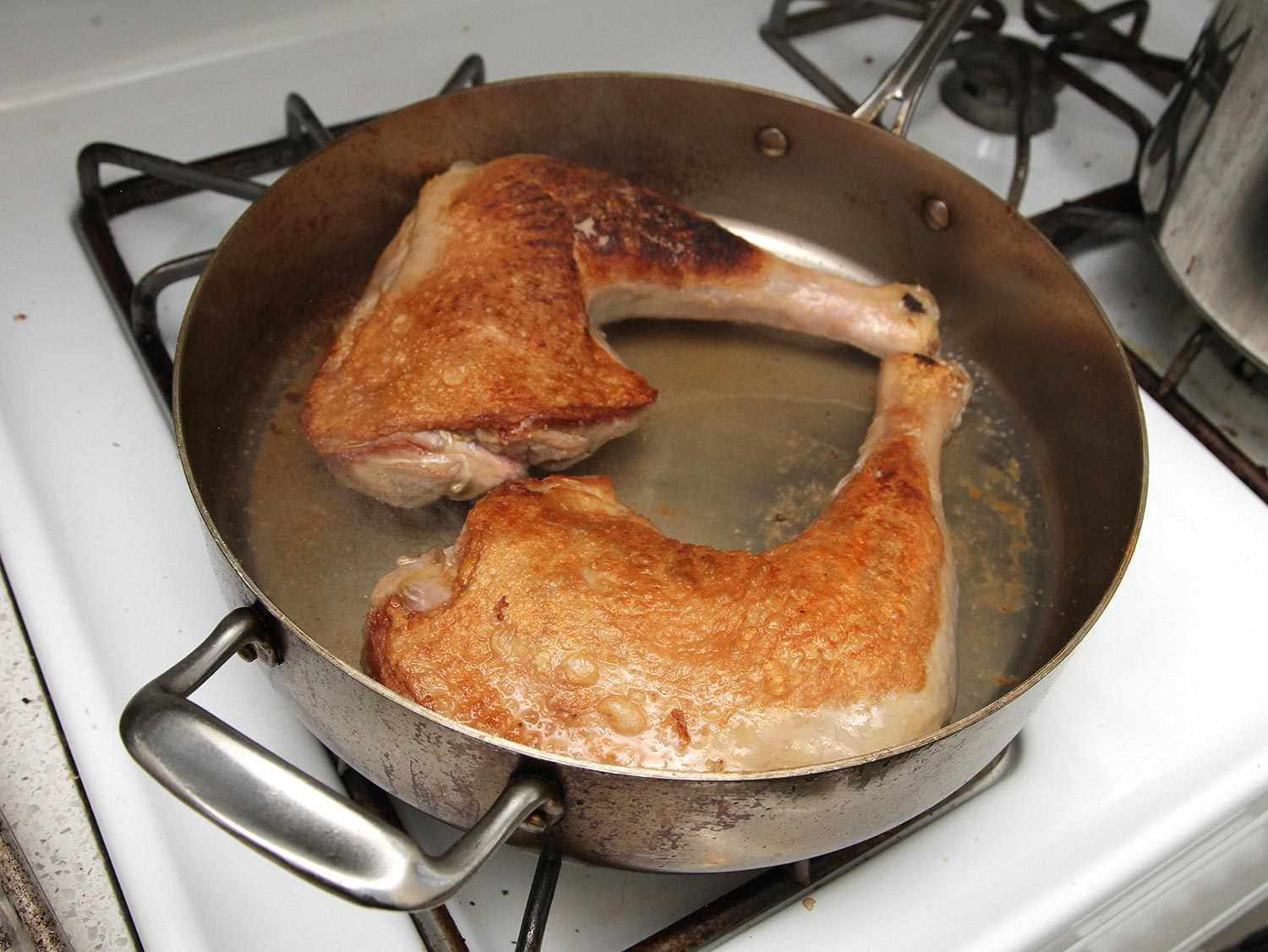 Turkey searing in a saute pan. 