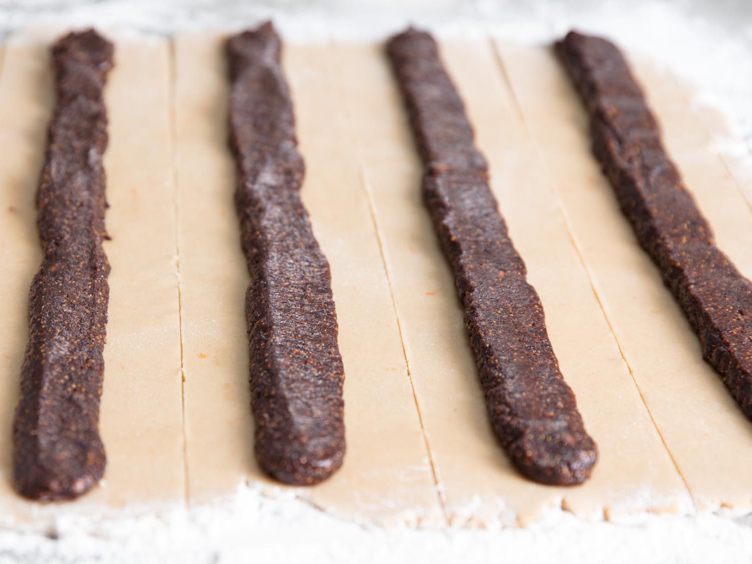 Strips of dough with fig filling piped down the center.