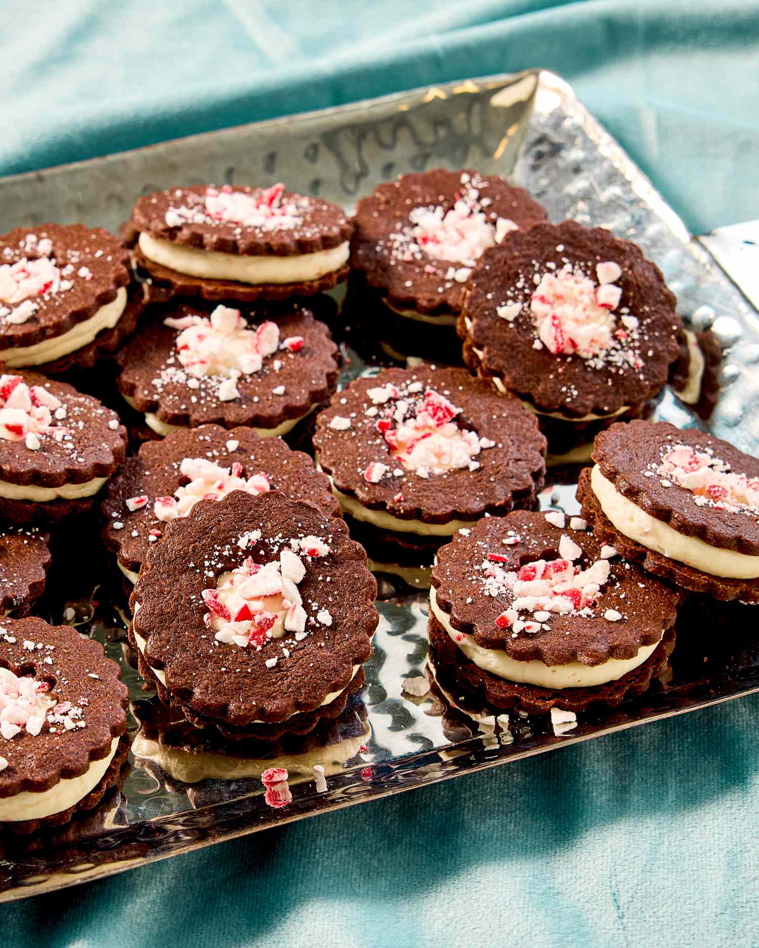 A tray of chocolate peppermint sandwich cookies topped with crushed peppermint candies