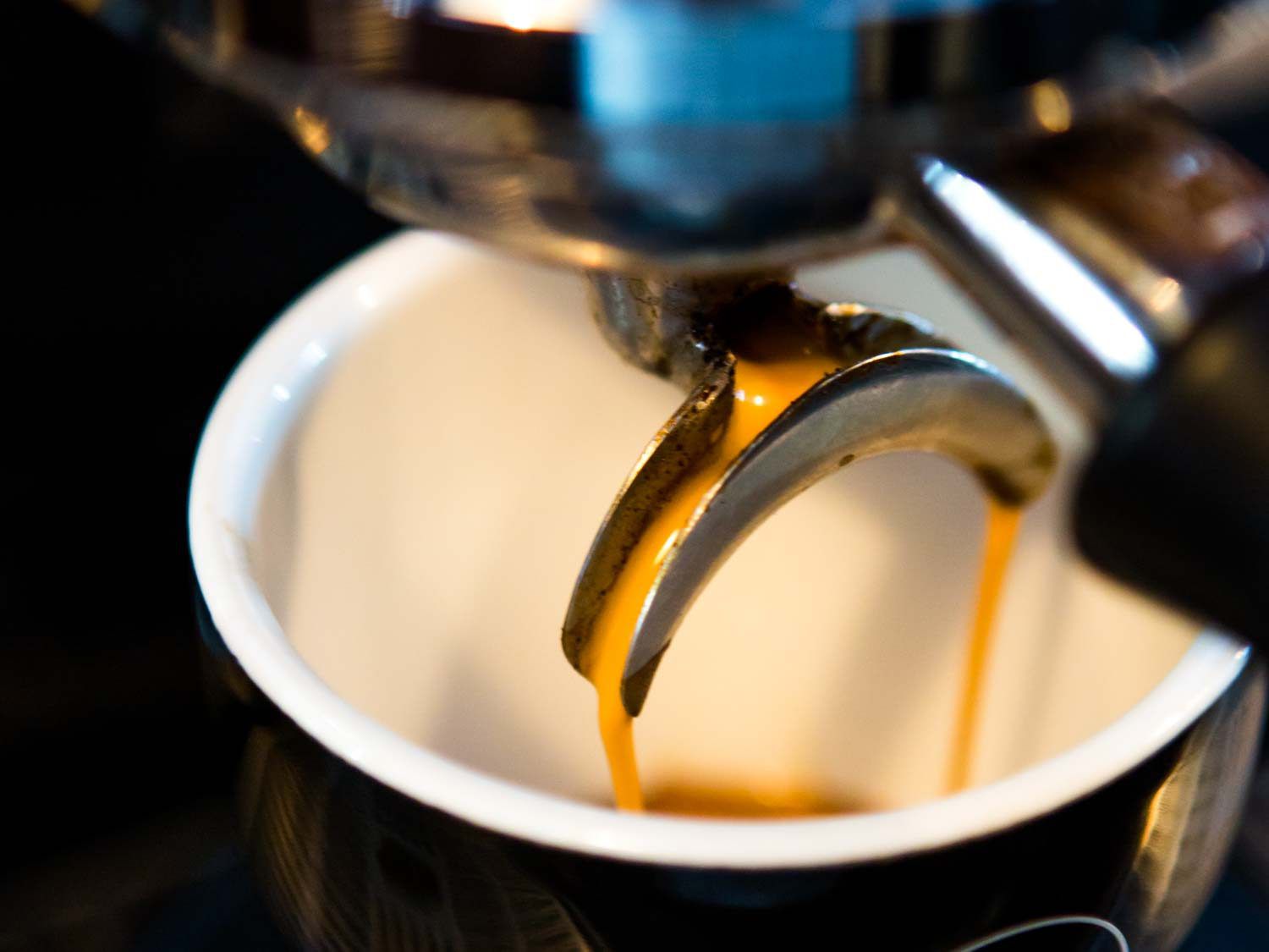 Espresso pouring from the machine into a coffee mug.