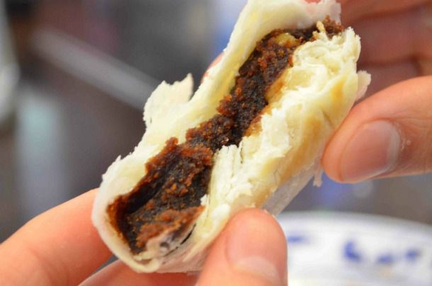 The author holds a half-eaten date walnut cake up to the camera.