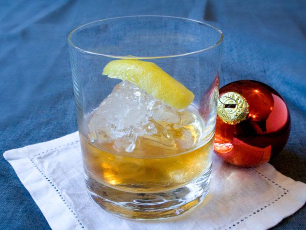 An apple brandy old fashioned, flanked by a Christmas tree ornament.