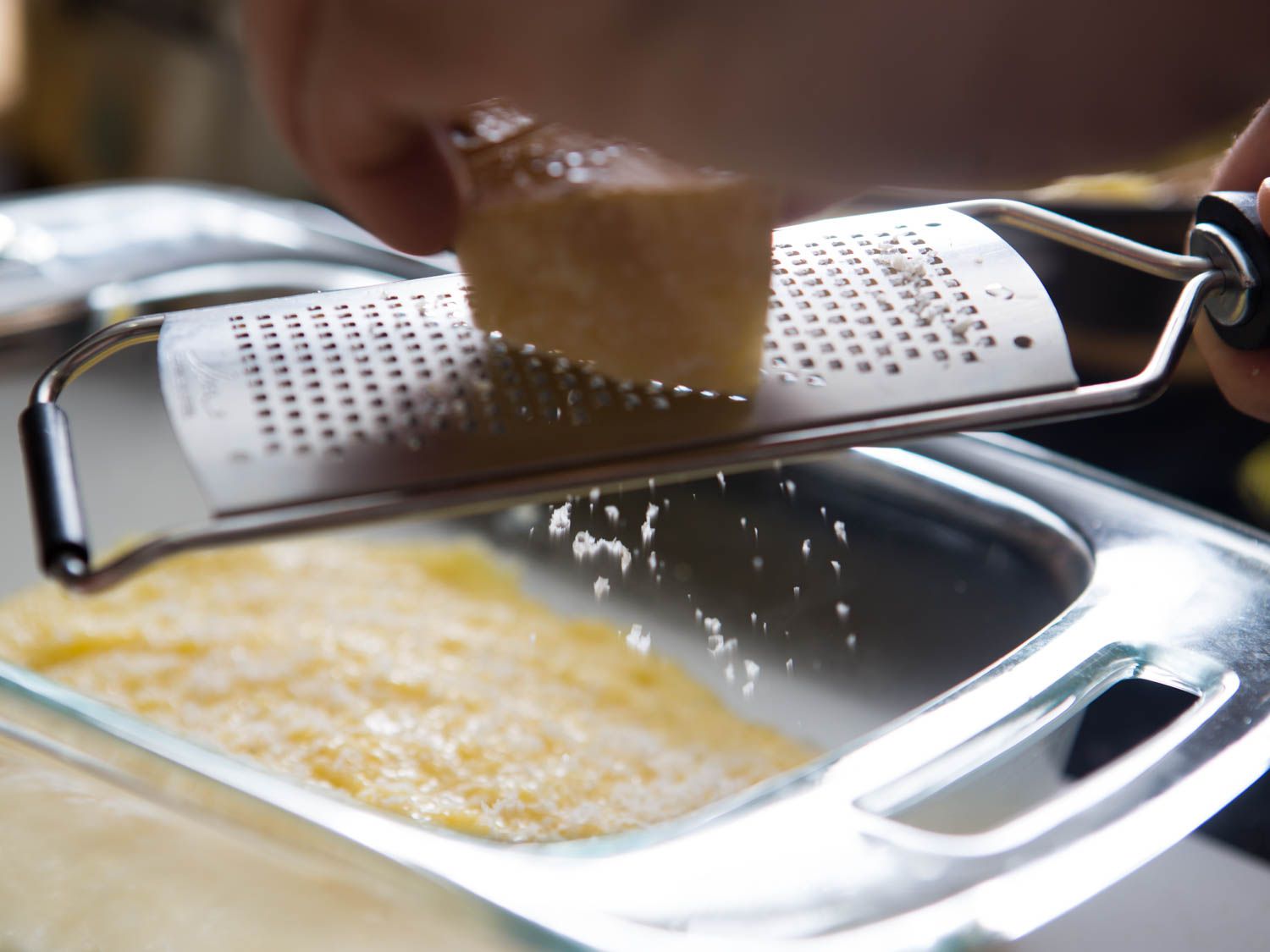 Parmesan is grated over the layer of the polenta.