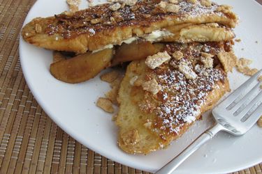 Closeup of Cinnamon Toast Crunch® Coated Apple Stuffed French Toast, served on a white plate.