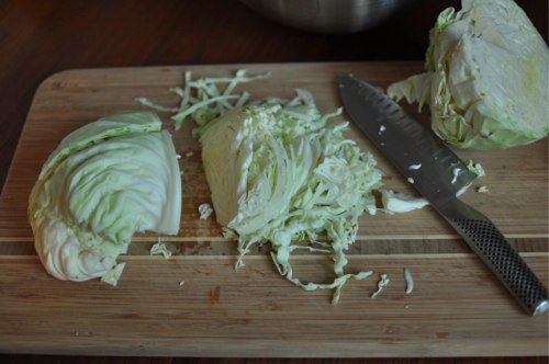 Cabbage is cut into shreds on a cutting board.