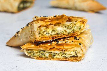 a borek cut in half to show the spinach and cheese filling