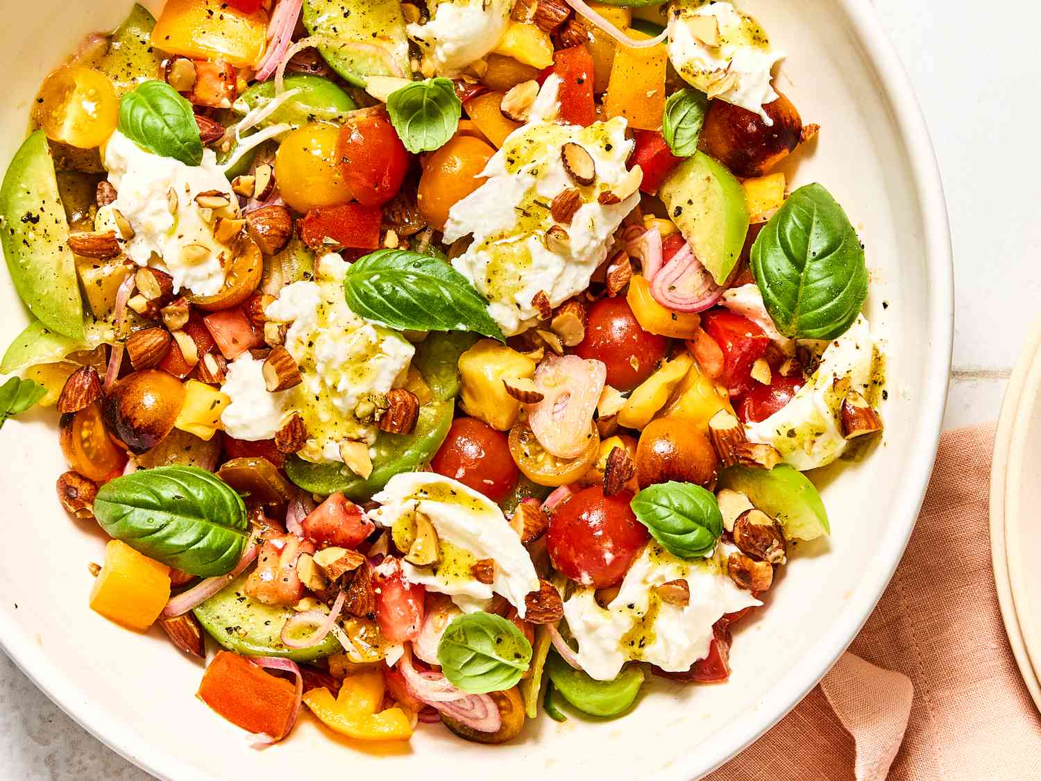 Tomato salad with sliced vegetables and fresh herbs in a bowl