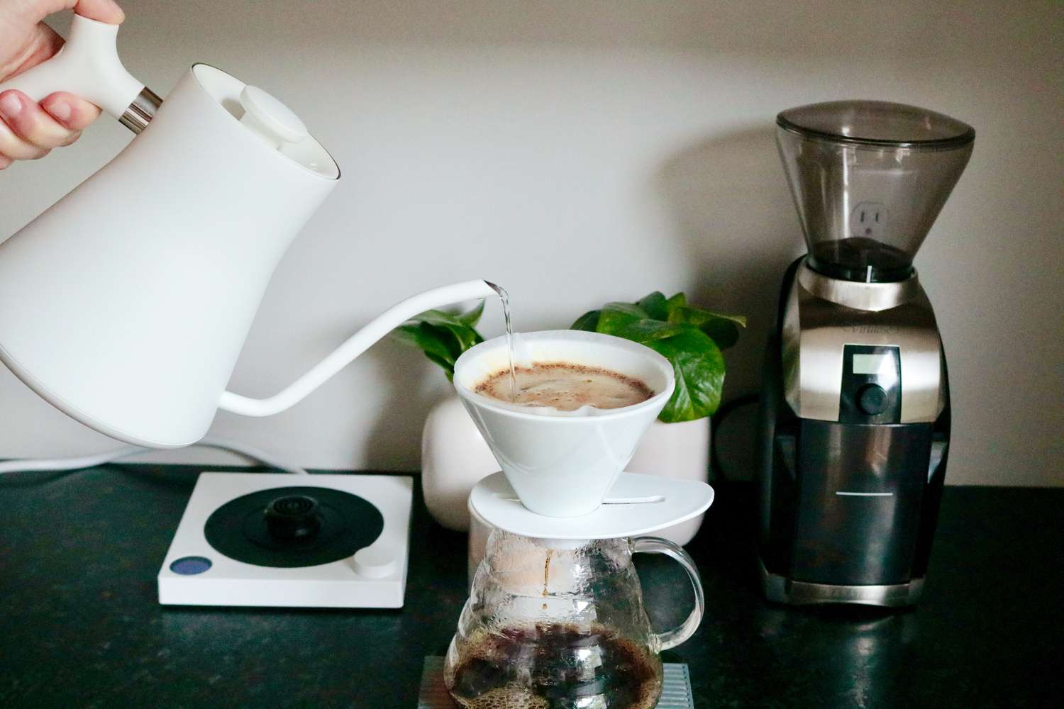 Brewing pourover coffee with a Hario brewer and using a gooseneck kettle to add water