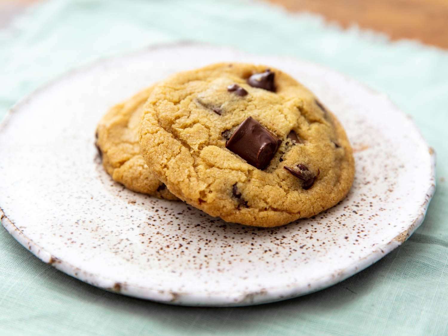 two golden yellow chocolate chip cookies on a plate
