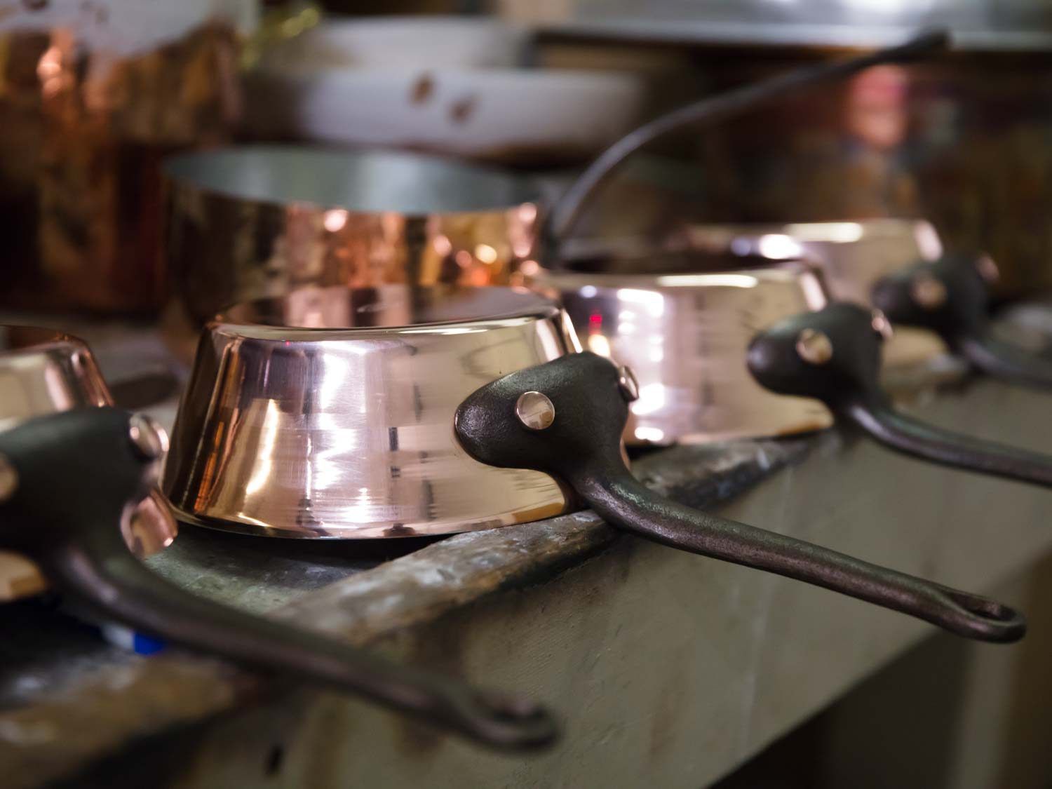 Copper flared saucepans on counter's edge