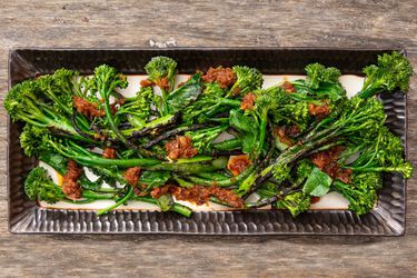 Overhead shot of charred broccolini with XO sauce on a platter