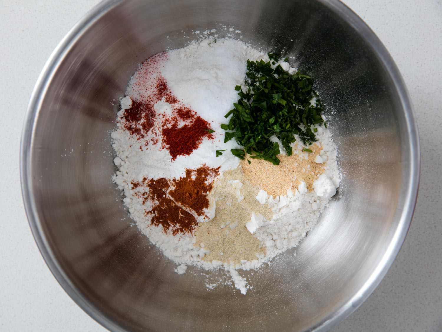 Overhead view of a mixing bowl with all of the dry ingredients for the biscuits added.