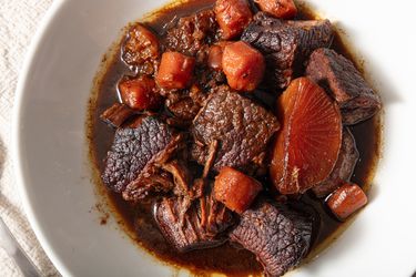 white dish of Cantonese braised brisket on a white tablecloth