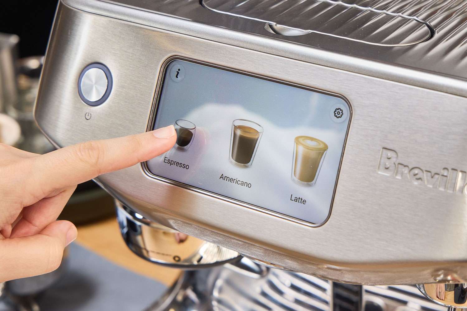A person presses a button on the Breville Oracle Jet Espresso Machine