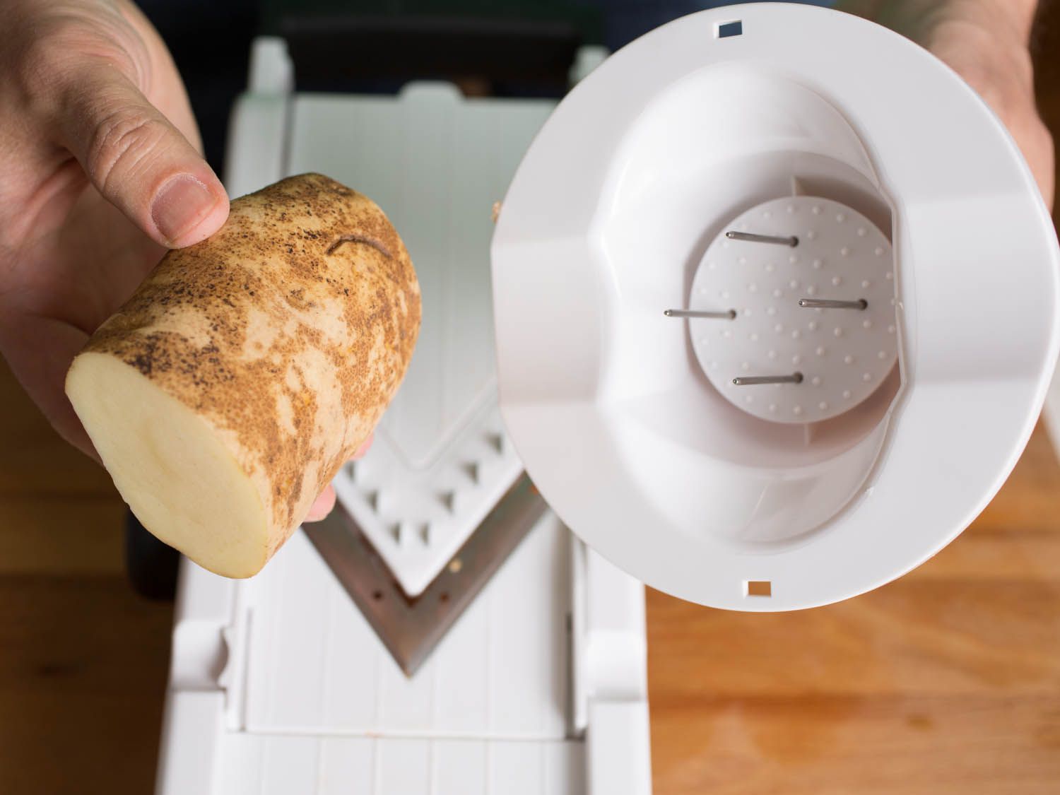 Potato being held next to the oxo's blade guard