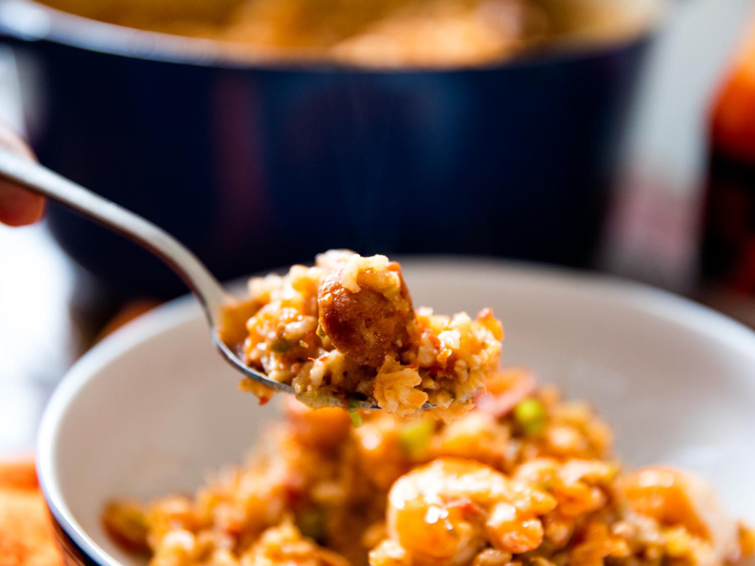 A spoon of jambalaya lifting from the serving bowl.