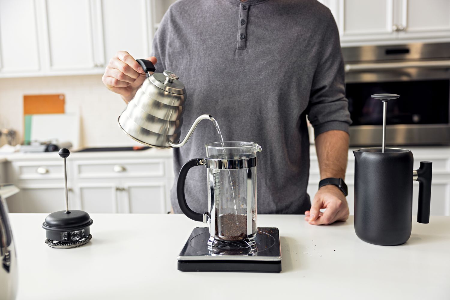 person pouring water into Bodum Chambord French Press Coffee Maker