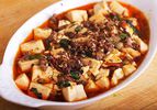 Mapo Tofu with ramps, served in a shallow, white, ovoid serving bowl.