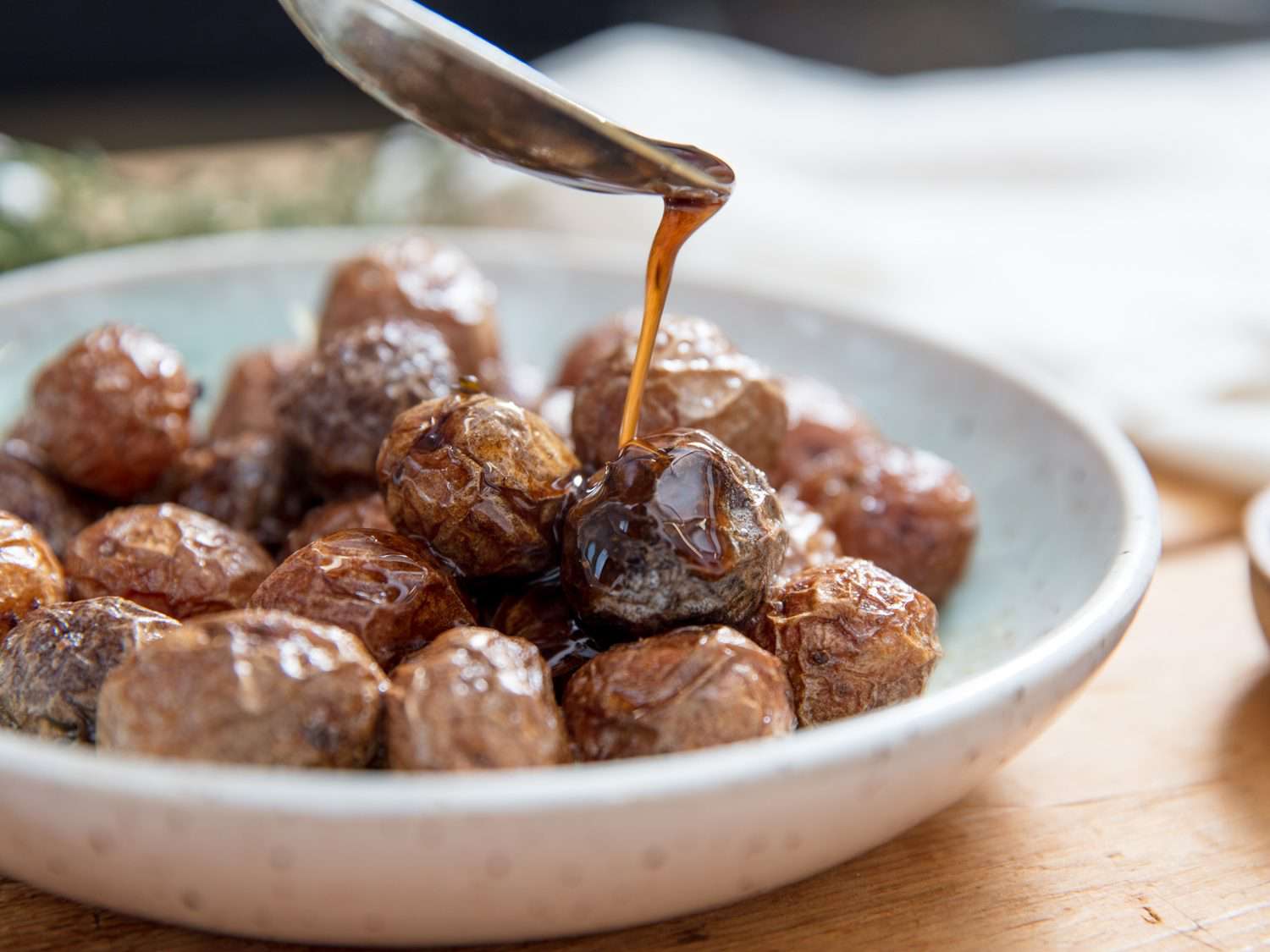 Drizzling brown butter over cooked new potatoes.