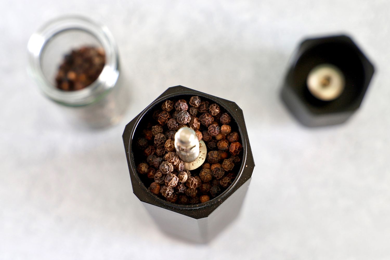 the interior of the hexclad pepper mill filled with peppercorns
