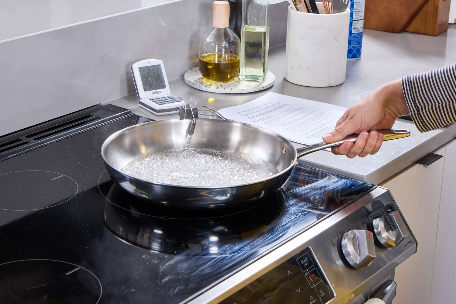 A person boils water in the Tramontina 12-Inch Stainless Steel Skillet